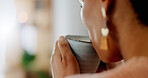 Closeup, face or woman with hands, coffee and drinking a beverage for morning, relax or break in living room of home. Person, tea or drink espresso, cappuccino or latte for peace or comfort in lounge