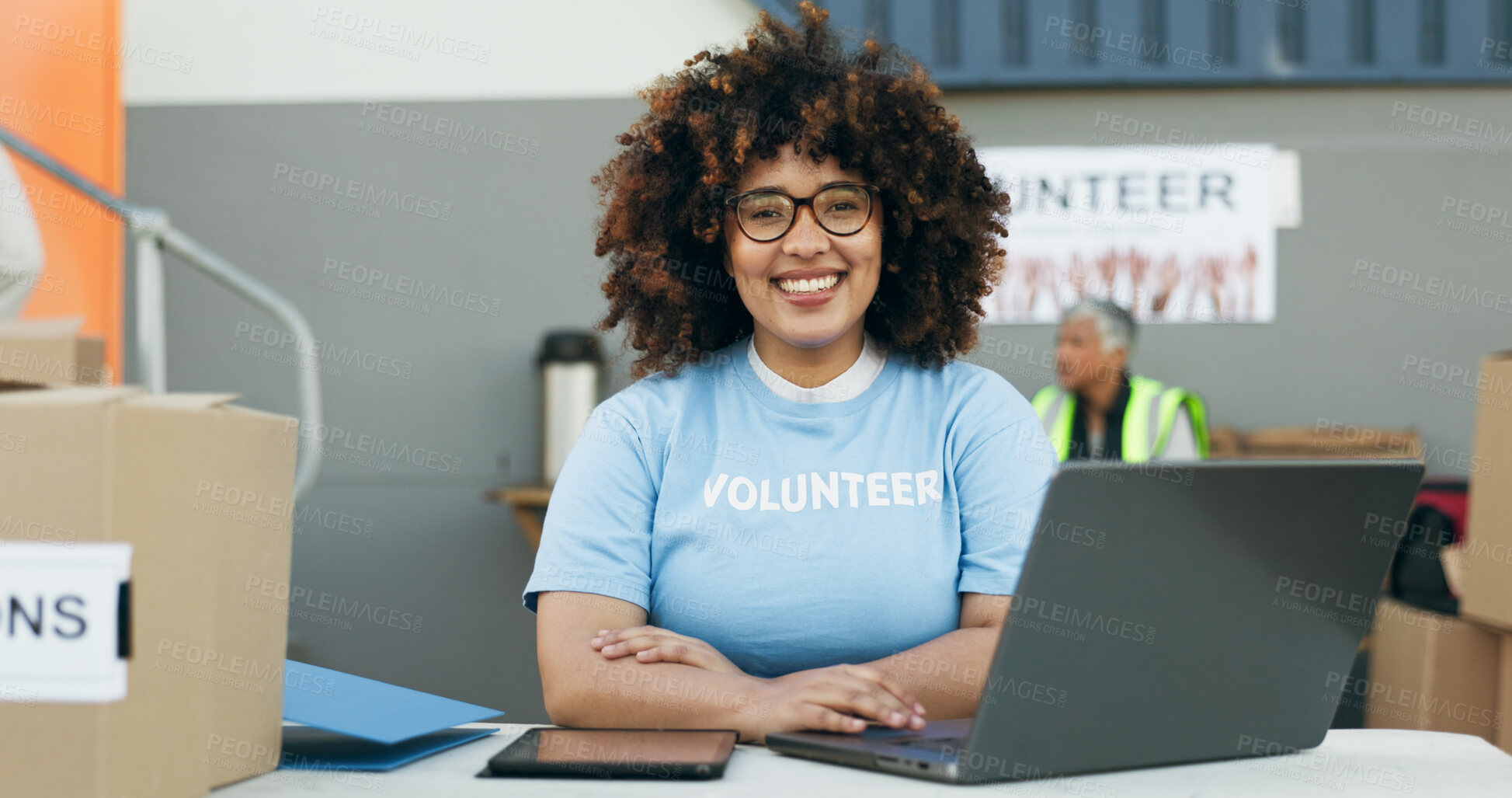 Buy stock photo Volunteer woman, laptop and portrait at clothes drive with smile, community service and kindness at desk. Girl, computer and social responsibility with donation boxes, charity and happy for helping