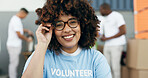 Volunteer woman, portrait and smile for charity, clothes drive and community service with kindness at desk. African girl, ngo and social responsibility with donation boxes, care or happy for helping