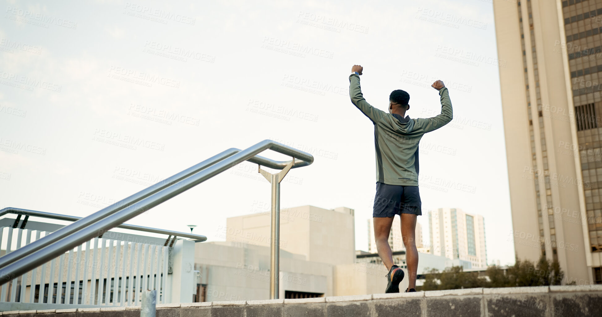 Buy stock photo Man, fitness and celebration in city with fist pump for achievement, workout or success in outdoor exercise. Rear view of male person, runner or athlete with hands up in victory for training in town