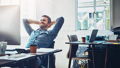 Buy stock photo Shot of a young businessman taking a break at his office desk
