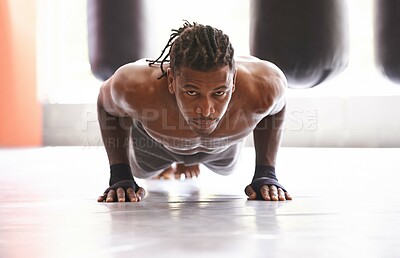 Buy stock photo Portrait of a young boxer doing pushups in a gym