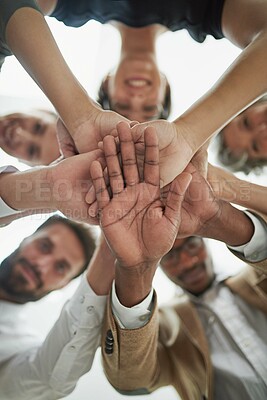Buy stock photo Low angle portrait of a group of businesspeople putting their hands in a pile