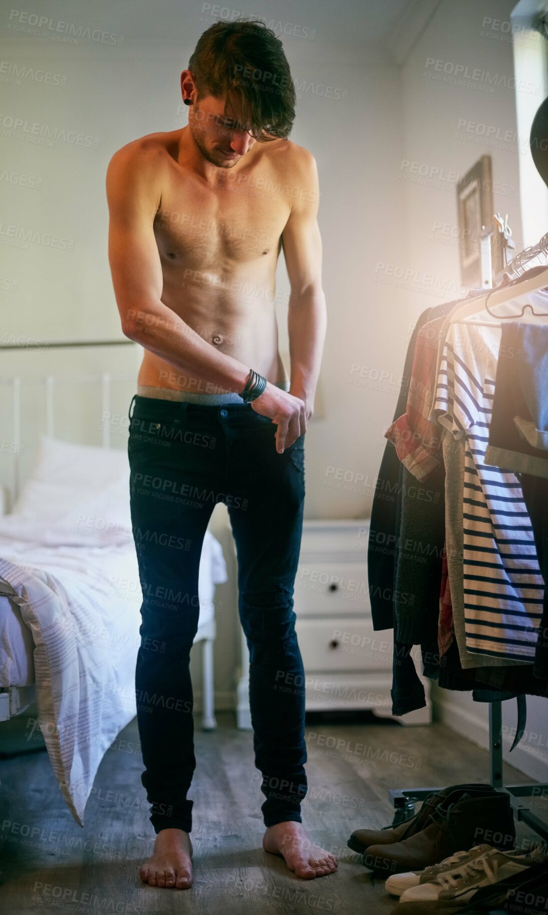 Buy stock photo Shot of a handsome young man getting dressed in his bathroom