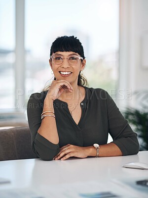 Buy stock photo Cropped portrait of an attractive young businesswoman sitting alone in her office with her hand on her chin