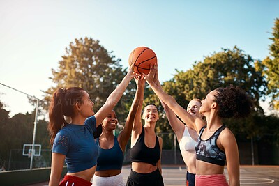 Buy stock photo Cropped shot of a diverse group of sportswomen holding a basketball together before playing a game during the day
