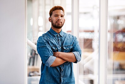 Buy stock photo Cropped portrait of a handsome young male designer standing with his arms folded in the office