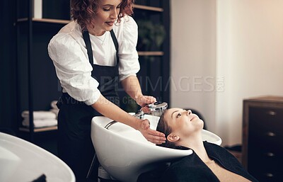 Buy stock photo Shot of a beautiful young woman getting her hair washed at the salon