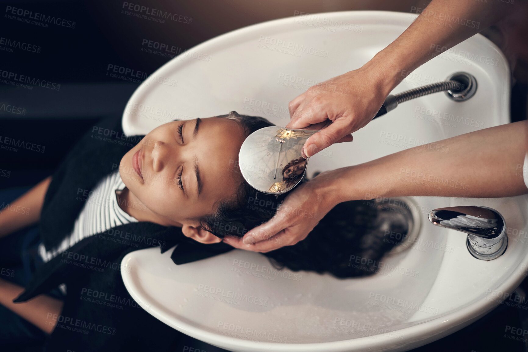 Buy stock photo Shot of a young girl getting her hair washed at the salon