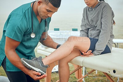 Buy stock photo Cropped shot of a handsome young male physiotherapist working on a female patient outside