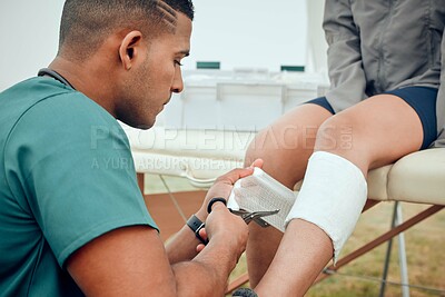 Buy stock photo Cropped shot of a handsome young male physiotherapist working on a female patient outside