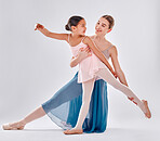 Ballet, trainer and girl training for performance, fitness and balance against grey studio background. Female dancer, mentor and ballerina practice, mentor or teaching with smile, support or learning