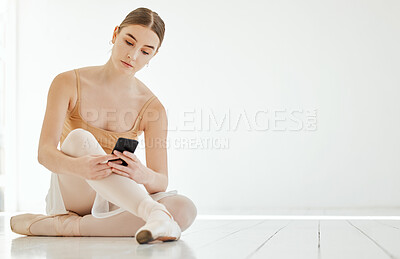 Buy stock photo Phone, dance and space with a ballerina on the floor of a studio for social media or communication. Ballet, mockup or networking app with a serious young dancer typing a text message on her mobile