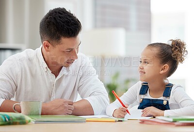 Buy stock photo Shot of a young father helping his daughter with her homework at home