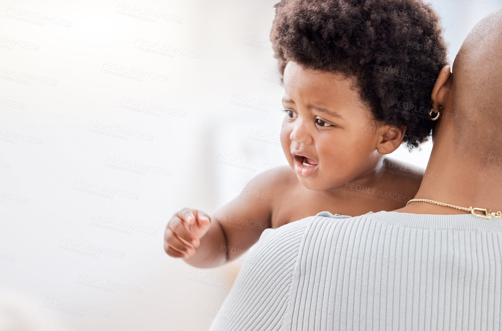 Buy stock photo Face, toddler and upset with cry in living room with person, carry or comfort by holding. African, little boy and afro with curiosity for child development, growth or milestone for health in home