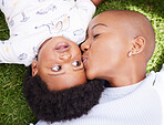 Mother, kiss and child on grass with black family, love and support together with baby in garden. Lawn, above and mom with happy kid, park smile and backyard with African mama and relax in nature