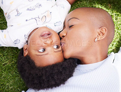 Buy stock photo Mother, kiss and child on grass with black family, love and support together with baby in garden. Lawn, above and mom with happy kid, park smile and backyard with African mama and relax in nature