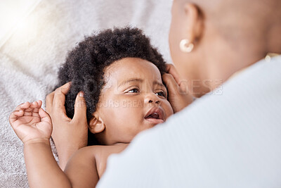 Buy stock photo Love, care and mother bonding with baby on a bed relaxing and playing together in nursery at home. Happy, maternal and young African mom with little newborn, child or kid in bedroom at modern house.