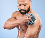 Shower, washing and man with sponge in studio for cleaning, hygiene and skincare on blue background. Dermatology, bathroom and person with soap, drops and cosmetics for wellness, health or self care