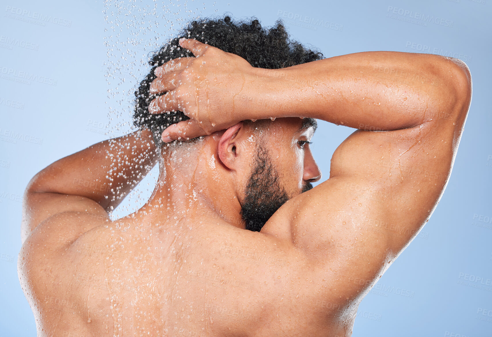 Buy stock photo Man, shower back and splash in studio with water, wash or hygiene with self care by blue background. Person, guy and muscle with hair, wellness or health for skin, natural dermatology and body