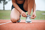 Running, track and person tie shoes in stadium for marathon training, exercise and cardio workout. Fitness, sports and closeup of runner tying sneaker laces for performance, race event and challenge
