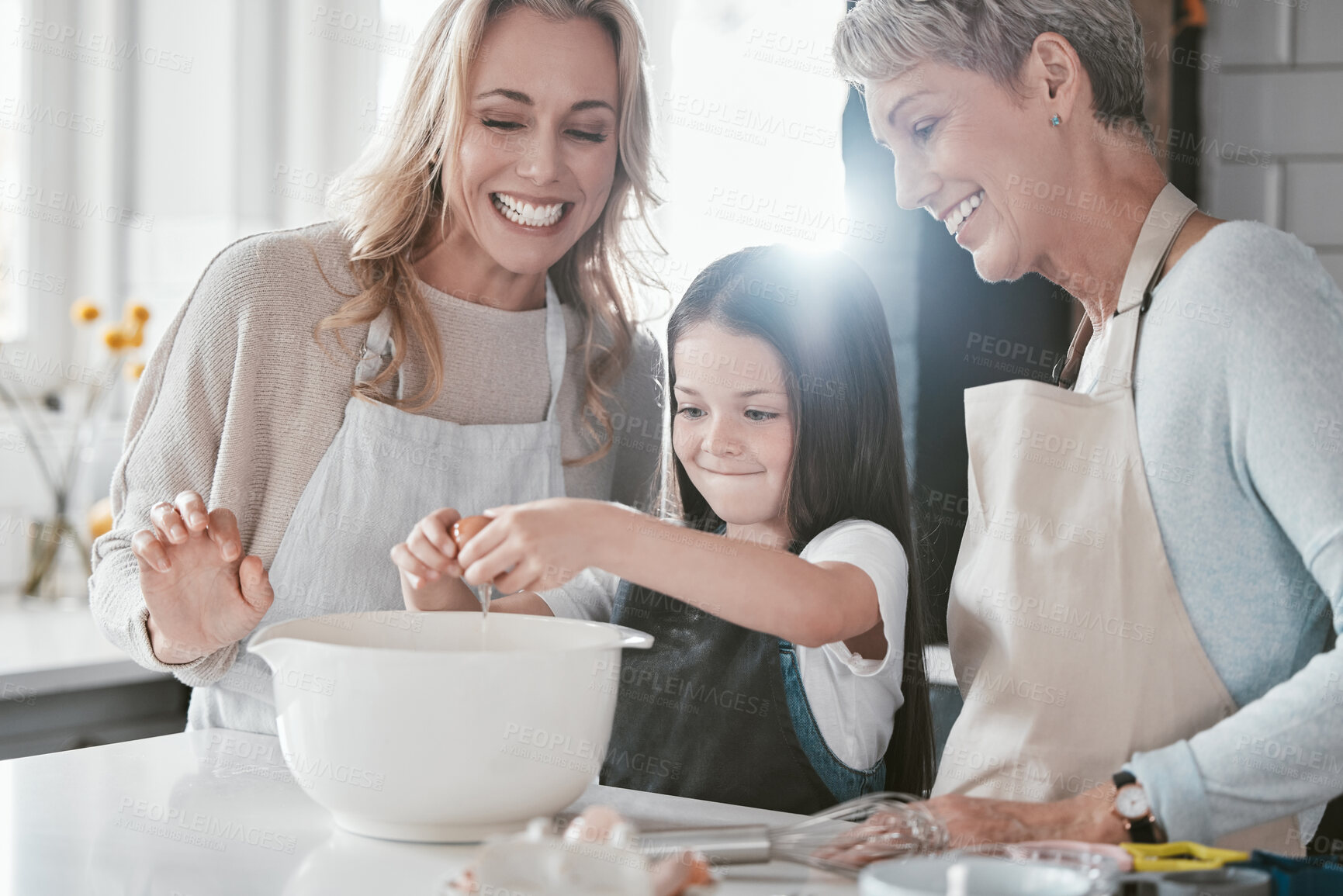 Buy stock photo Baking, excited and girl with mother and grandmother in the kitchen cooking as a team. Food, teamwork and child with mom and senior woman learning to crack an egg while helping with dinner in a house