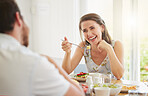 Couple, eating breakfast and home with talking, happy or food for health, wellness or diet in morning. Woman, man and comic laugh together for conversation, memory or relax on vacation in dining room