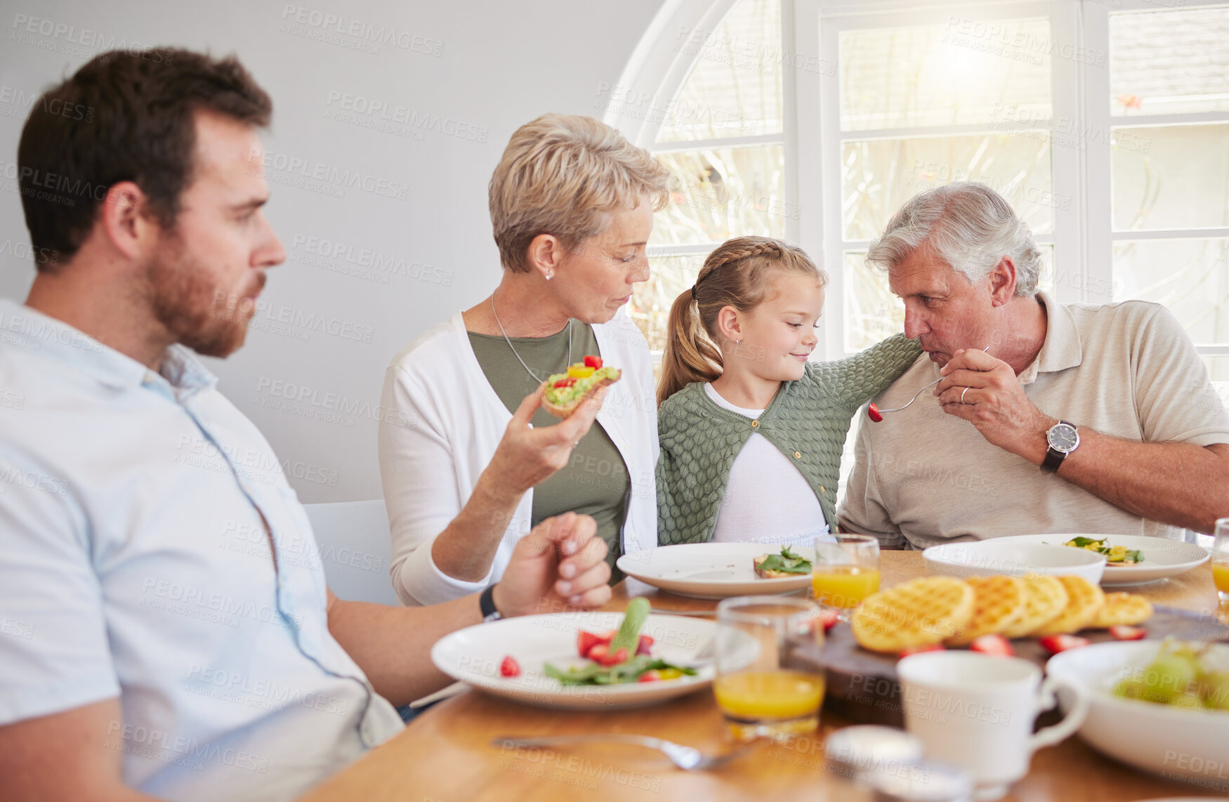 Buy stock photo Big family home, children and together at breakfast, eating or talk for help, dad or grandparents at table. Men, women and kid for food, fruit or lunch for memory, conversation or chat in dining room