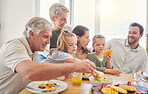 Parents, children and grandparents at breakfast, happy and eating together on holiday, bonding and food in family home. Men, women and girl kids with fruits, waffles and diet choice in dining room