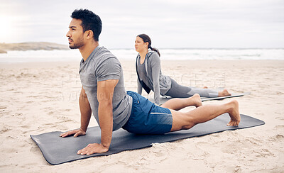 Buy stock photo Exercise, yoga and wellness with a couple on the beach for a mental health or awareness workout in the morning. Fitness, pilates or mindfulness with a young man and woman by the ocean or sea for zen