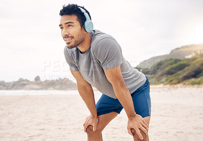 Buy stock photo Fitness, headphones and portrait of man on beach running for race, marathon or competition training. Sports, workout and young male athlete listen to music, radio or playlist for exercise by ocean.