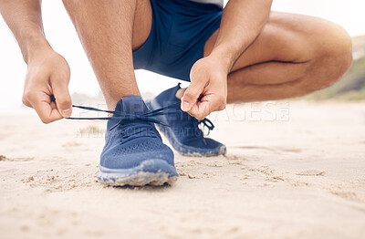 Buy stock photo Running shoes, hands and fitness man at a beach for training, exercise or morning cardio zoom. Legs, closeup and male runner with sneakers lace outdoor for wellness, workout or marathon practice run