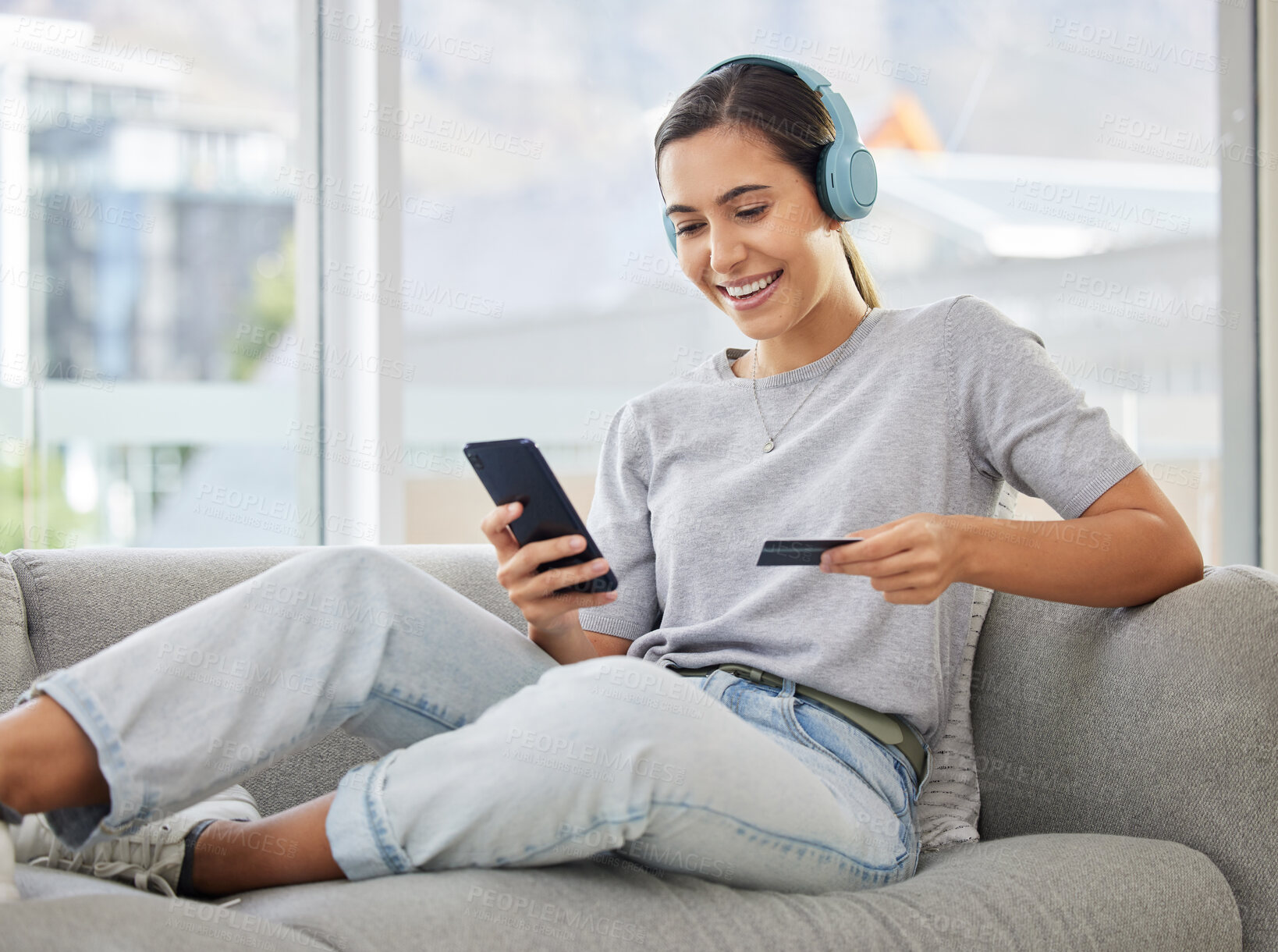 Buy stock photo Happy, headphones and phone with credit card and woman at home with purchase, music and smile. Online shopping, tech and internet with banking and audio with mobile by a sofa with digital buying