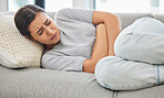 Woman, stomach pain and stress on sofa, sick or menstruation with anxiety, gas or virus in home living room. Girl, abdomen and emergency for gut health, constipation or cramp on lounge couch in house