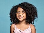 Happy, smile and girl child in a studio with afro hair standing by a blue background alone. Happiness, excited and beautiful young kid from Mexico smiling with a positive, joyful and fun mindset.