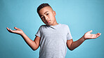 Doubt, question and shrug from child with confused facial expression, don't know gesture and raised hands. Young boy, African youth and face portrait of puzzled black kid isolated on blue background