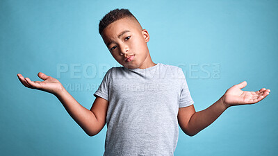 Buy stock photo Doubt, question and shrug from child with confused facial expression, don't know gesture and raised hands. Young boy, African youth and face portrait of puzzled black kid isolated on blue background