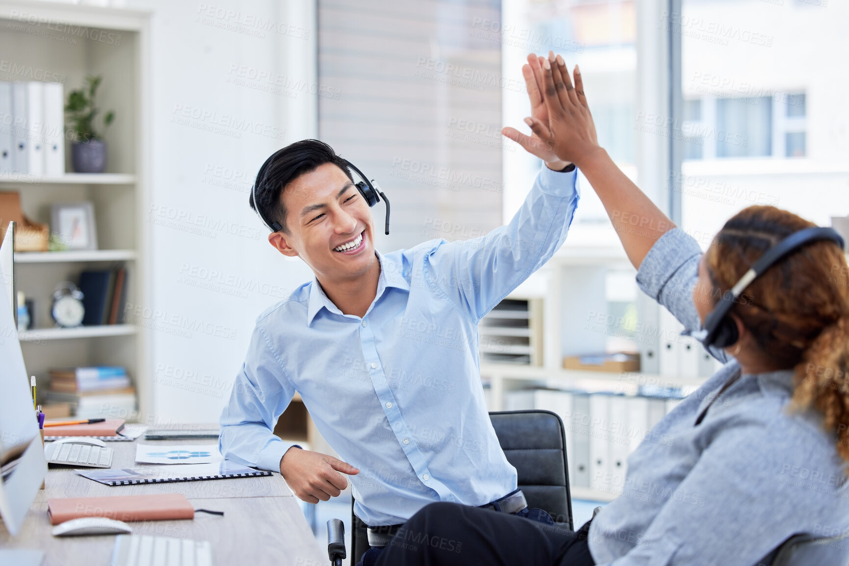 Buy stock photo Call center, high five and team celebrate success at desk with headset for telemarketing teamwork. Asian man and a woman agent excited for sales deal, customer service, bonus achievement and target