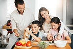 Healthy food, cooking and bonding of family making, preparing and cutting ingredients for meal together in a home kitchen. Happy parents teaching fun kids about fresh, homemade and nutritious eating