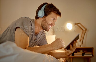 Buy stock photo Headphones, digital tablet and in bed watching online movies, videos or series at night in house bedroom. Man on entertainment news or internet film streaming app or website on home 5g wifi network.