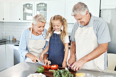 Buy stock photo Grandparents, girl child in kitchen and cooking healthy food with vegetables on cutting board for happy family lunch at home. Natural, organic nutrition and clean diet for senior people in retirement