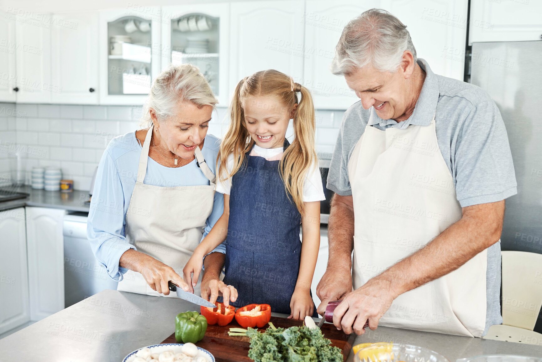 Buy stock photo Grandparents, girl child in kitchen and cooking healthy food with vegetables on cutting board for happy family lunch at home. Natural, organic nutrition and clean diet for senior people in retirement