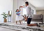 Family, father and daughter dancing for fun, energy and love in the living room feeling happy holding hands to dance at home. Man or dad and girl child moving to favorite song on fathers day in house