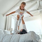 Playful, bedroom and father holding his child while relaxing on the bed together in their home. Happy, smile and portrait of girl kid playing, resting and bonding with her dad in the room of a house.