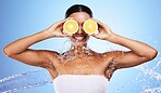 Black woman, water splash and orange skincare for natural beauty routine, organic skin health and vitamin c detox treatment. Happy smile, facial cleaning spa and advertising mockup on blue background