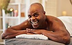 Black man, wellness and relax in spa portrait with happiness, excited and smile on massage bed at resort. Man, happy and vacation for health, peace and calm for self care, retreat or physical therapy