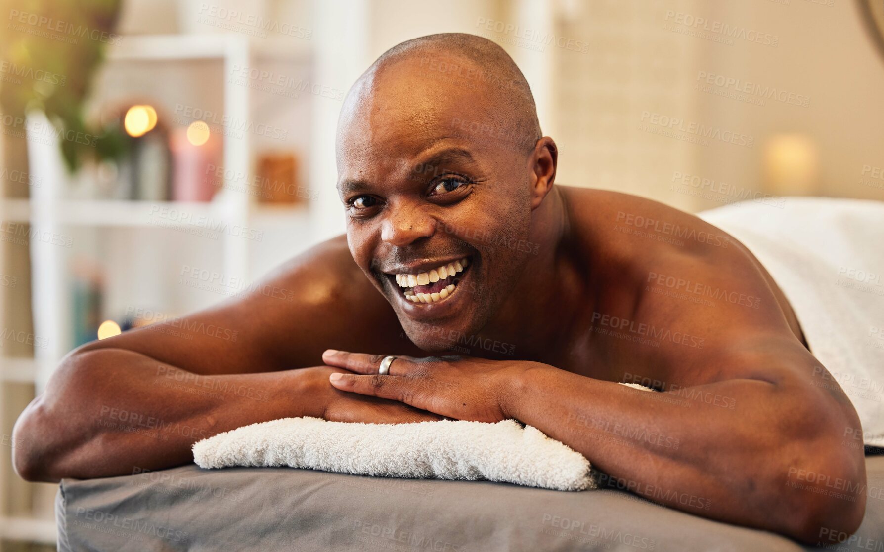 Buy stock photo Black man, wellness and relax in spa portrait with happiness, excited and smile on massage bed at resort. Man, happy and vacation for health, peace and calm for self care, retreat or physical therapy