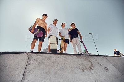 Buy stock photo Skateboard, friends and sports with a man athlete group at a skateboard for training or recreation together. Fitness, workout and exercise with a male sport group skating on a ramp outdoor from below