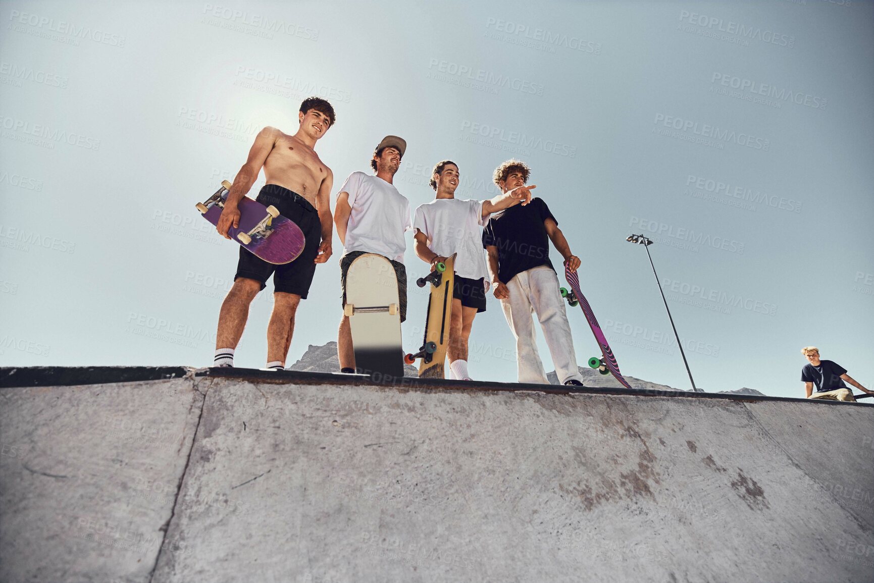 Buy stock photo Skateboard, friends and sports with a man athlete group at a skateboard for training or recreation together. Fitness, workout and exercise with a male sport group skating on a ramp outdoor from below