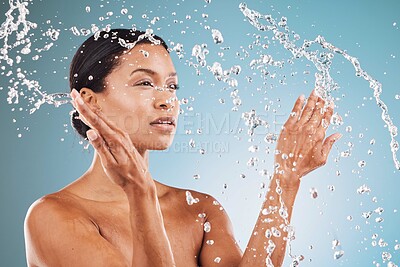 Buy stock photo Beauty, skincare and black woman with splash of water for cleaning, hygiene and body care routine. Self care, wellness and healthy skin of model thinking with water splash in blue studio.